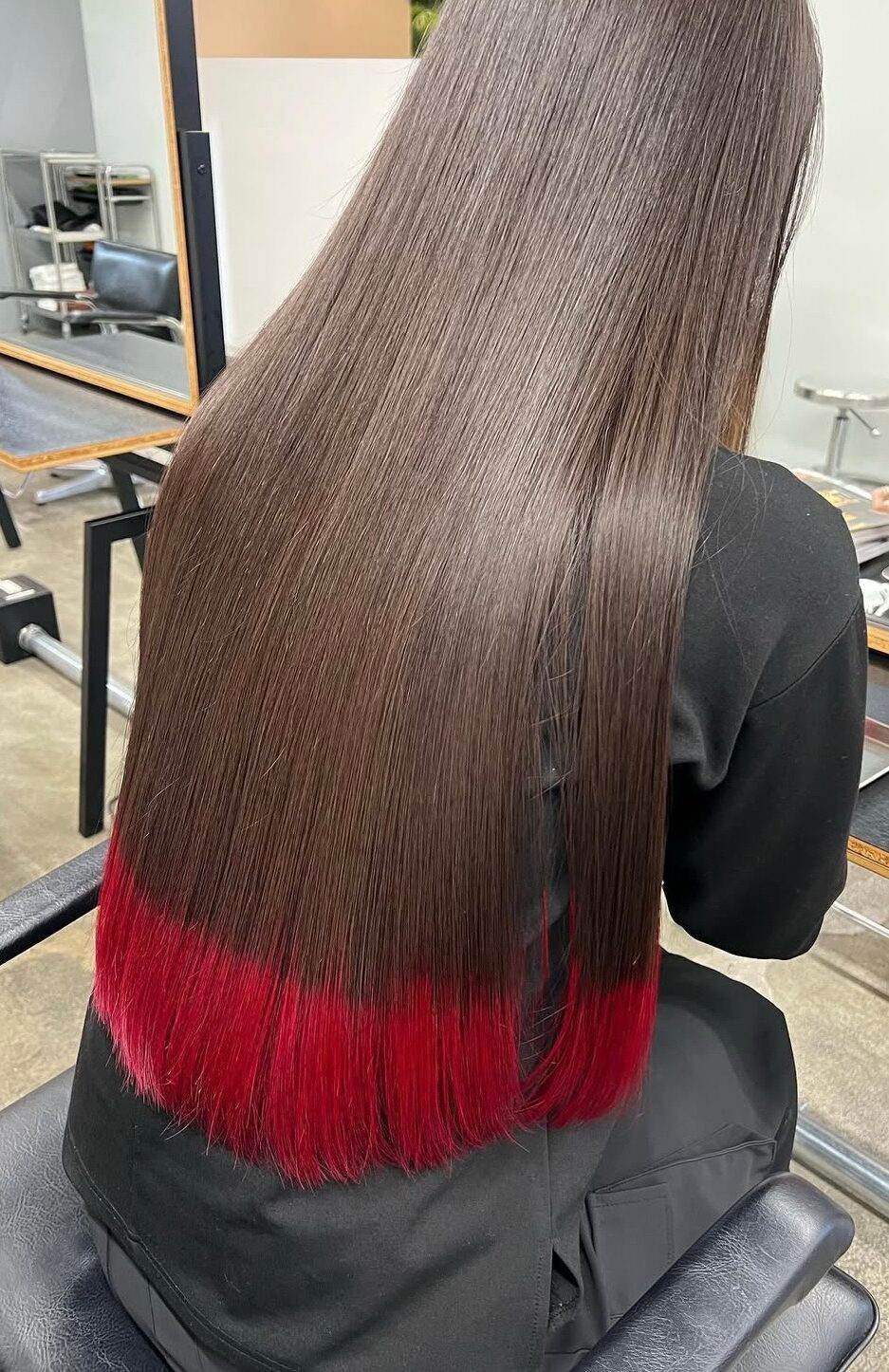 Back view of dark brown long hair with red dip-dye ends, showing a vibrant crimson finish for a low-maintenance 2026 look.